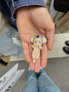 a person is holding a small toy in their hand with an elephant on it's finger