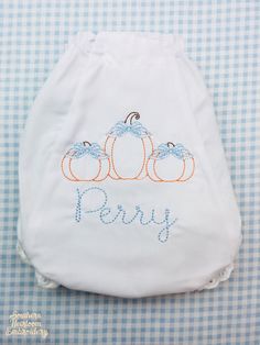 a cloth diaper with embroidered pumpkins and the words pepy written on it