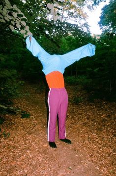 a person standing in the middle of a forest with their arms stretched out to reach something