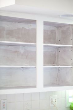 a kitchen with white cupboards and tile backsplashes that have been stripped off