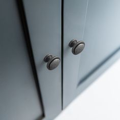 two knobs on the side of a gray cabinet