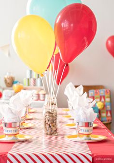 a table topped with lots of balloons next to cups filled with nuts and marshmallows