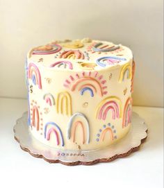 a white cake with rainbows and stars on it