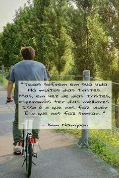 a man riding a bike down a path with a quote on the back of it