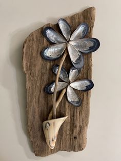 a piece of wood with shells and flowers on it