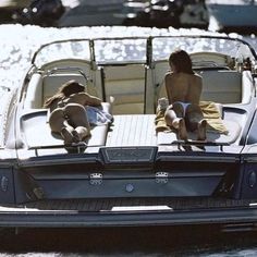 two people sitting on the back of a boat