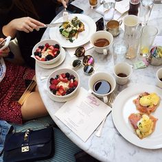 people sitting at a table with plates of food