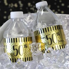 two plastic water bottles sitting on top of an ice bucket filled with clear cubes