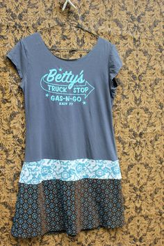 a women's t - shirt hanging on a wall with the words bettys truck stop printed on it