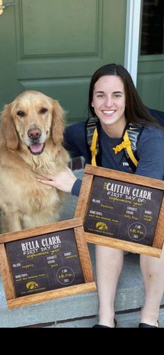 a woman sitting on the steps with her dog and two framed menus in front of her