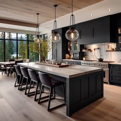 a large kitchen with lots of counter space and lights hanging from the ceiling over the island