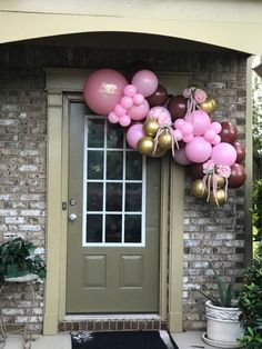 a front door decorated with pink, brown and gold balloons