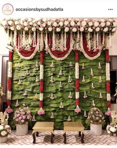 a decorated stage with flowers and decorations on the wall, along with two benches in front of it