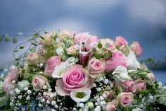 a bouquet of pink and white flowers sitting on top of a table