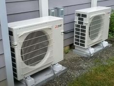 two air conditioners sitting next to each other on the side of a house,