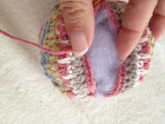 a hand is holding a small crocheted object