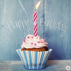 a cupcake with a lit candle on it sitting in front of a blue background