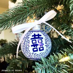 a blue and white ornament hanging from a christmas tree