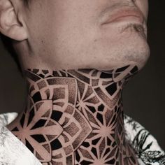 a man with a neck tattoo that has intricate designs on his neck and neckline