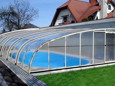 a house with a swimming pool in the middle of it's lawn and grass