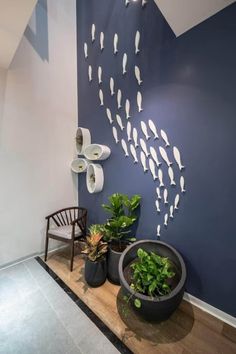 the wall is painted blue and has fish on it, along with two potted plants