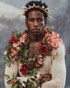 a man with flowers around his neck wearing a flower garland on his head and chest