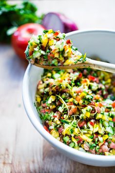 a white bowl filled with chopped vegetables on top of a wooden table