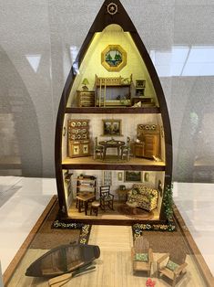 a doll house with furniture and accessories in the shape of a boat is on display