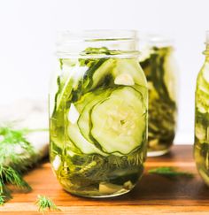 cucumbers and herbs in mason jars on a cutting board