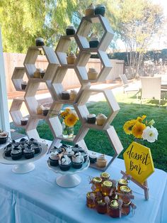 a table topped with cupcakes and desserts on top of a blue table cloth