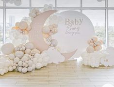 balloons are arranged in the shape of moon and clouds on display at a baby shower