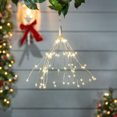 christmas lights hanging from the ceiling in front of trees with red bows and garlands