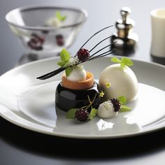 two desserts on a white plate with blackberries and raspberry garnishes