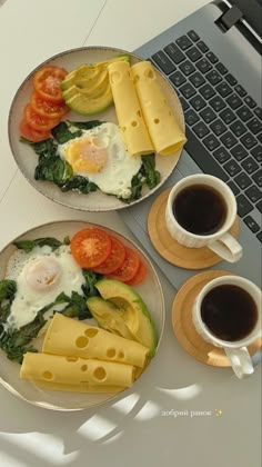 two plates filled with food next to cups of coffee