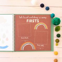 an open notebook with the words we loved watching so many firsts on it next to pom poms