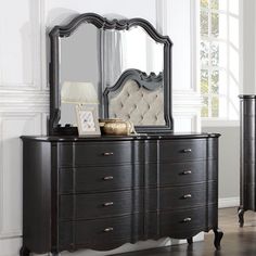 a bedroom with a dresser and mirror in it