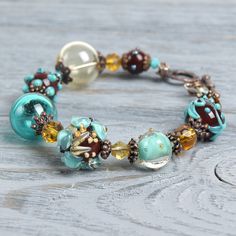 "This Turquoise floral lampwork boho bracelet is a perfect gift for women! This glass is rather durable as it is put in a very high temperature after the bead is made. This lampwork bracelet fits a 15.5-16.5cm (6.1\"-6.5\" inch) diameter wrist. If you need bigger or smaller size bracelet, please, write me the diameter of your wrist when making an order. Dimentions: 21cm. Materials: artist lampwork beads, metal and glass beads, metal fittings. Colors used: teal, turquoise, chocolate brown. Please Kawaii Bracelet, Teal Bracelet, Lampwork Bracelets, Flower Girl Bracelets, Girl Bracelet, Bracelet Flower, Bohemian Bracelet, Diy Jewelry Inspiration, Jewelry Styles