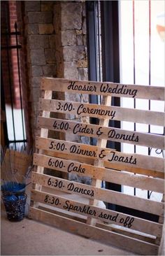 a wooden sign sitting on top of a table next to a window with writing on it