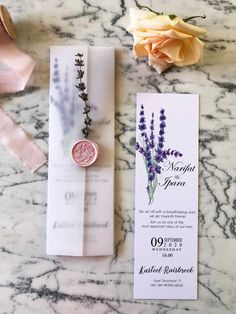 the wedding stationery is laid out on top of the marble table with flowers and ribbon