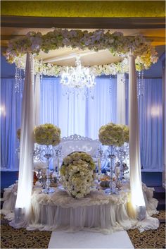 an elegant wedding setup with white flowers and chandelier