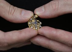 a gold pendant with sapphires forming a cross inside a circle of diamonds, with one edge melted and misshapen, handmade from 18- or 22-carat gold, probably in the 1800's or late 1700's found... Mysterious Jewelry, Burmese Python, Florida Everglades, Eastern Airlines, The Everglades, Old Planes, Everglades Florida, 22 Carat Gold