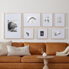 a living room filled with furniture and framed pictures on the wall above it's coffee table