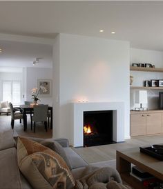 a living room filled with furniture and a fire place in the middle of a room