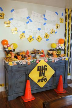 a table topped with lots of desserts and orange traffic cones sitting on top of a hard wood floor