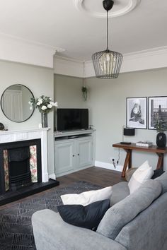 a living room filled with furniture and a flat screen tv on top of a fireplace