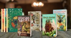 three books are sitting on a wooden table