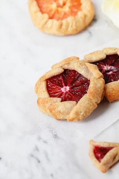 three small pies with blood orange slices on them