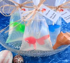 three bags filled with sea shells on top of a blue table