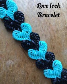 the loom loop bracelet is made with black, blue and turquoise yarns on a wooden table