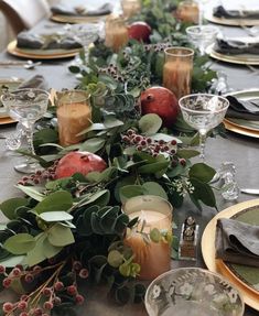 the table is set with candles, plates and napkins for an elegant holiday dinner